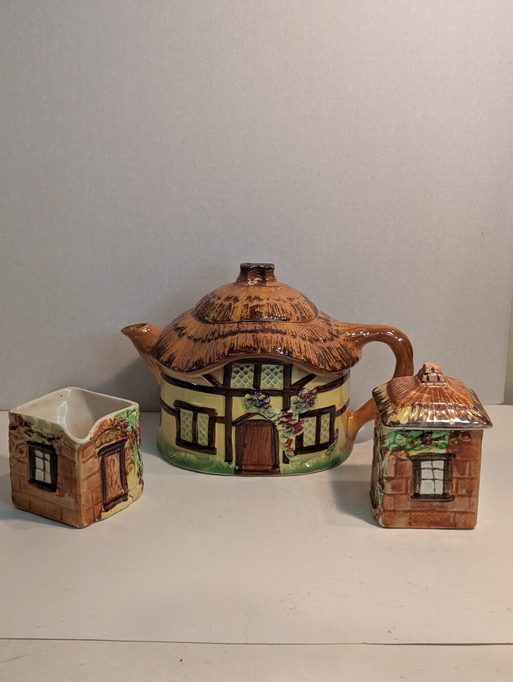 A vintage Burlington Ware Devon Cobb Cottage Teapot, creamer, and lidded sugar.